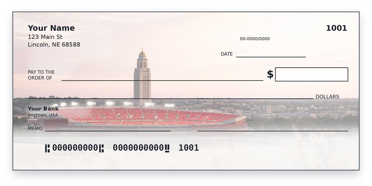 Nebraska Husker checks design – red-seated stadium and capitol tower beyond prairie grass at dusk, personal check mockup